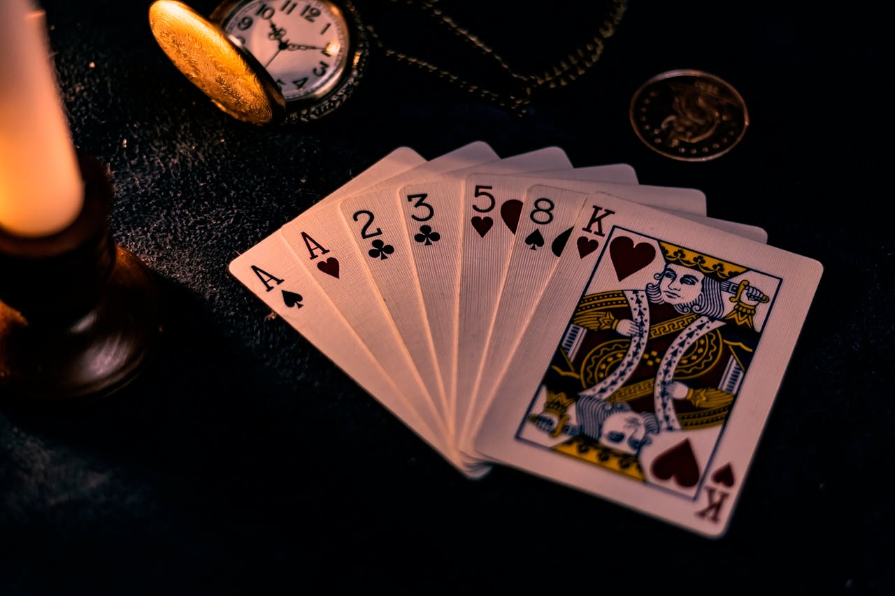 services-bg A dimly lit close-up of playing cards with a pocket watch, showcasing a nostalgic casino vibe.