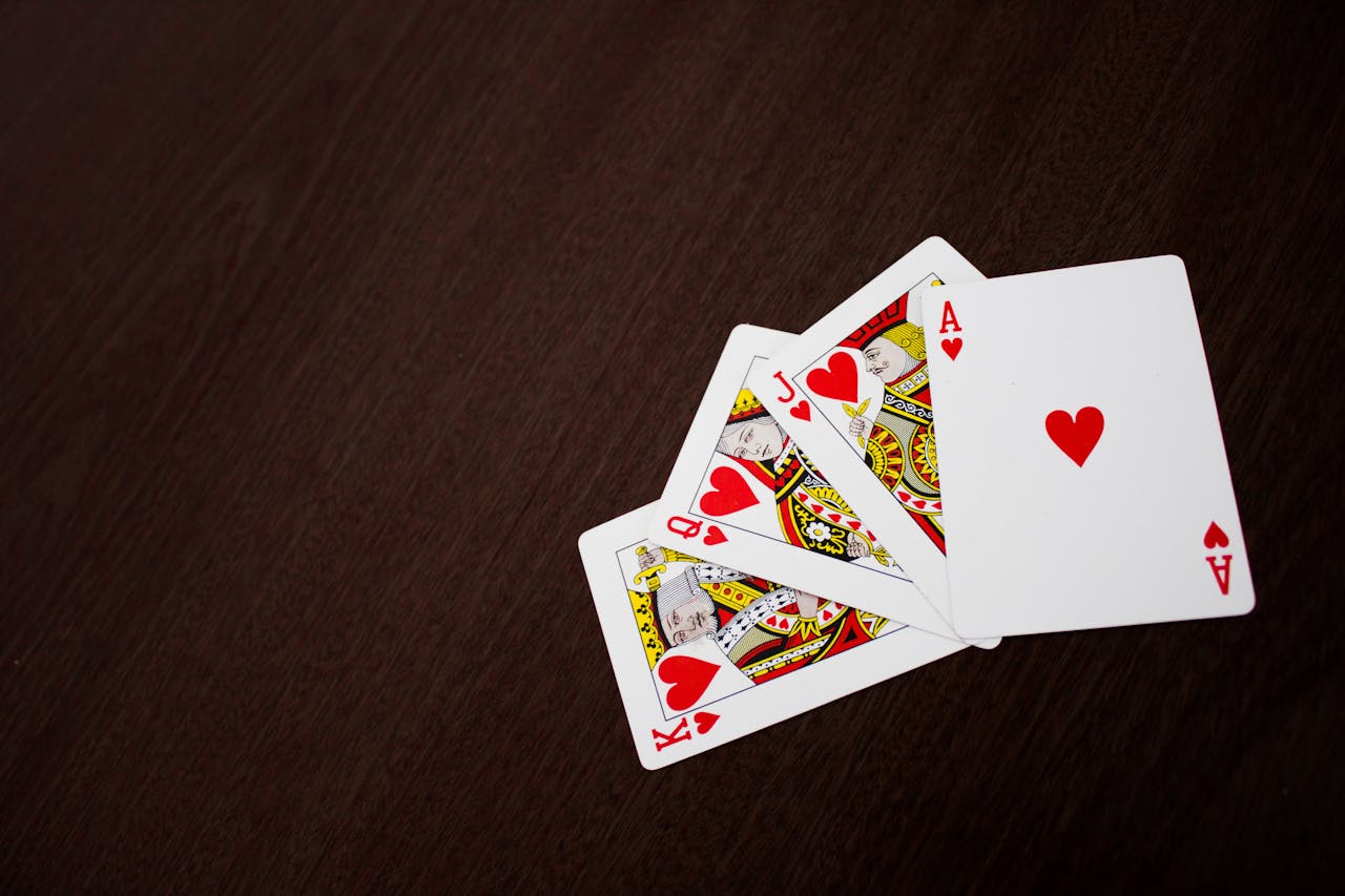 services-04 Elegant flat lay of playing cards featuring ace of hearts on a wooden surface.