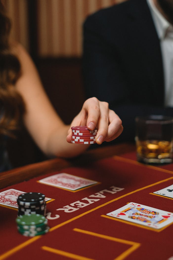 our-story Close-up of a poker game with chips, cards, and whiskey in a casino setting.