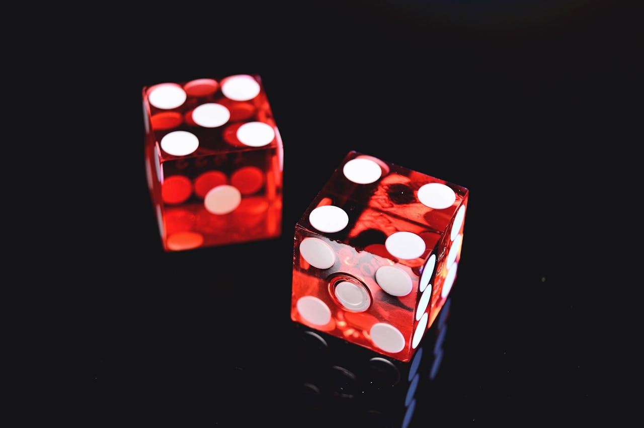 about-bg Close-up of two red dice on a shiny black background symbolizing luck and chance.